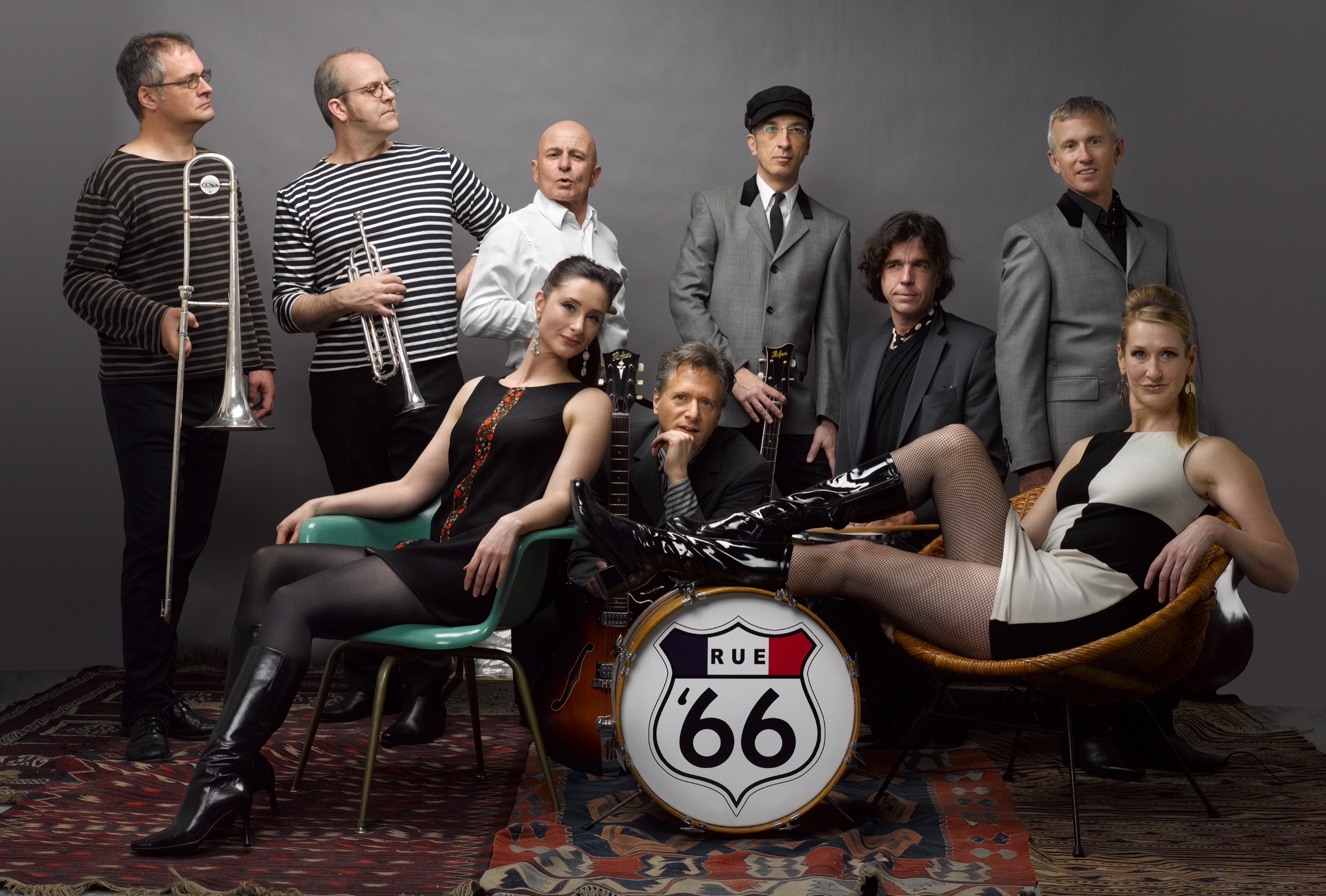 Rue '66 nine-piece band portrait around a bass drum bearing the Rue '66 shield