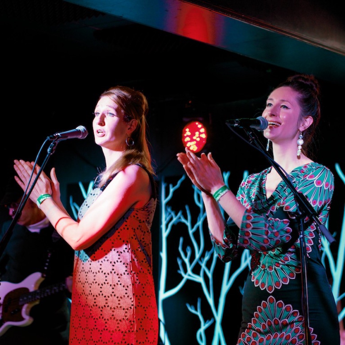 Two Rue '66 vocalists clapping at the microphones